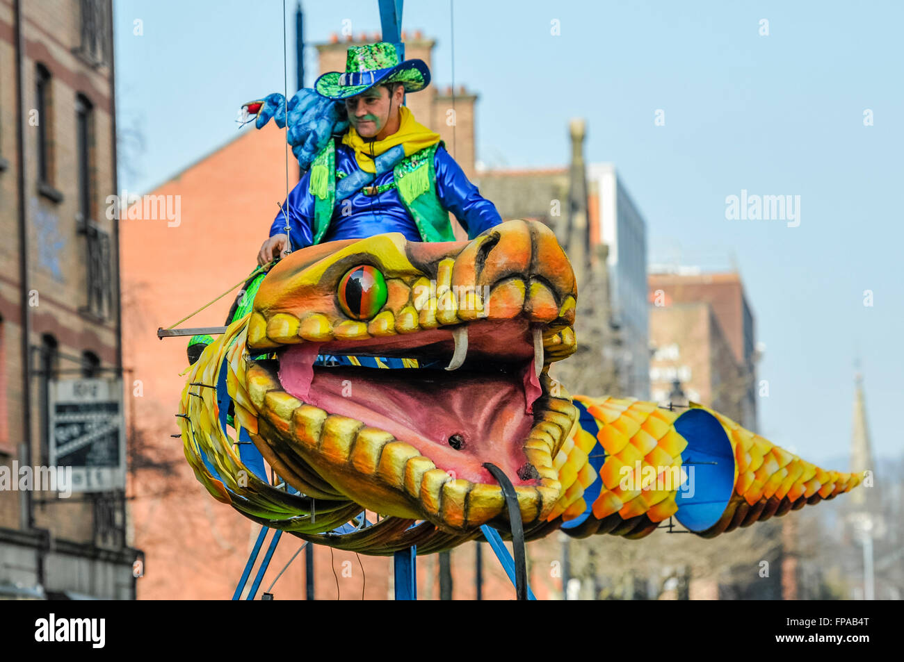 Belfast, Northern Ireland, UK. 17th March, 2016. A man rides a giant snake at the annual Saint Patrick's Parade. Credit:  Stephen Barnes/Alamy Live News Stock Photo