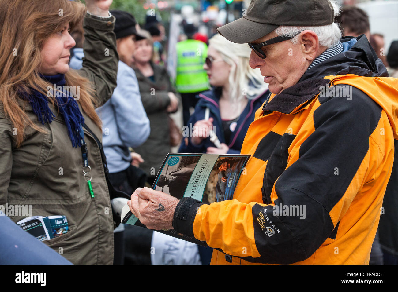 London, UK. 18th March 2016. Ric O'Barry, star of dolphin-hunting film 'The Cove', signs a copy of his book 'Behind The Dolphin Smile' at a protest opposite the Japanese embassy against the brutal annual slaughter of dolphins at Taiji in Japan Credit:  Mark Kerrison/Alamy Live News Stock Photo