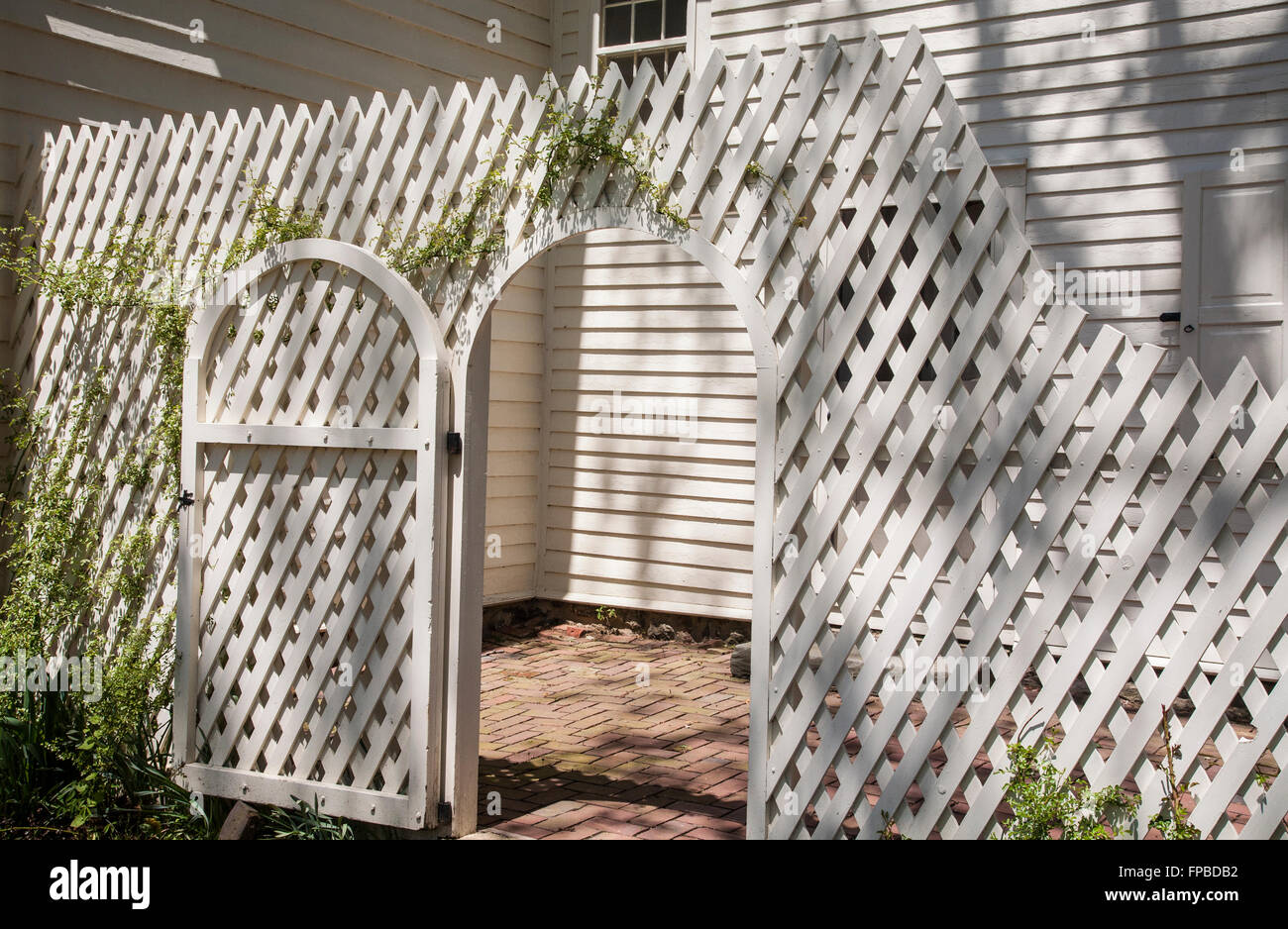 Vintage white lattice fence wall and wooden garden gate of a garden room, Freehold Township, Monmouth County, New Jersey, USA, US,  privacy fence Stock Photo