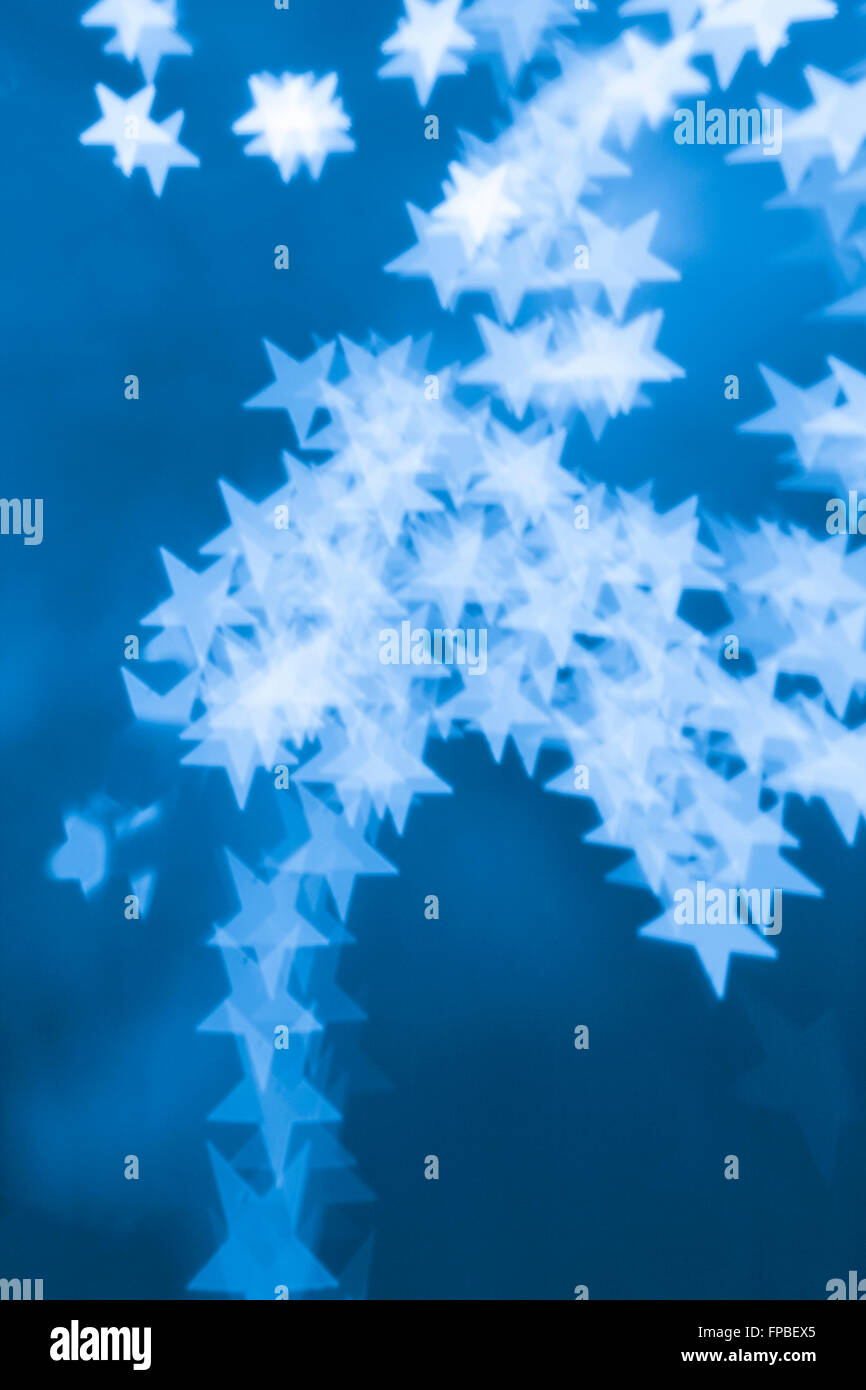 Lensbaby photo of holiday lights resulting in bokeh of blue stars Stock Photo