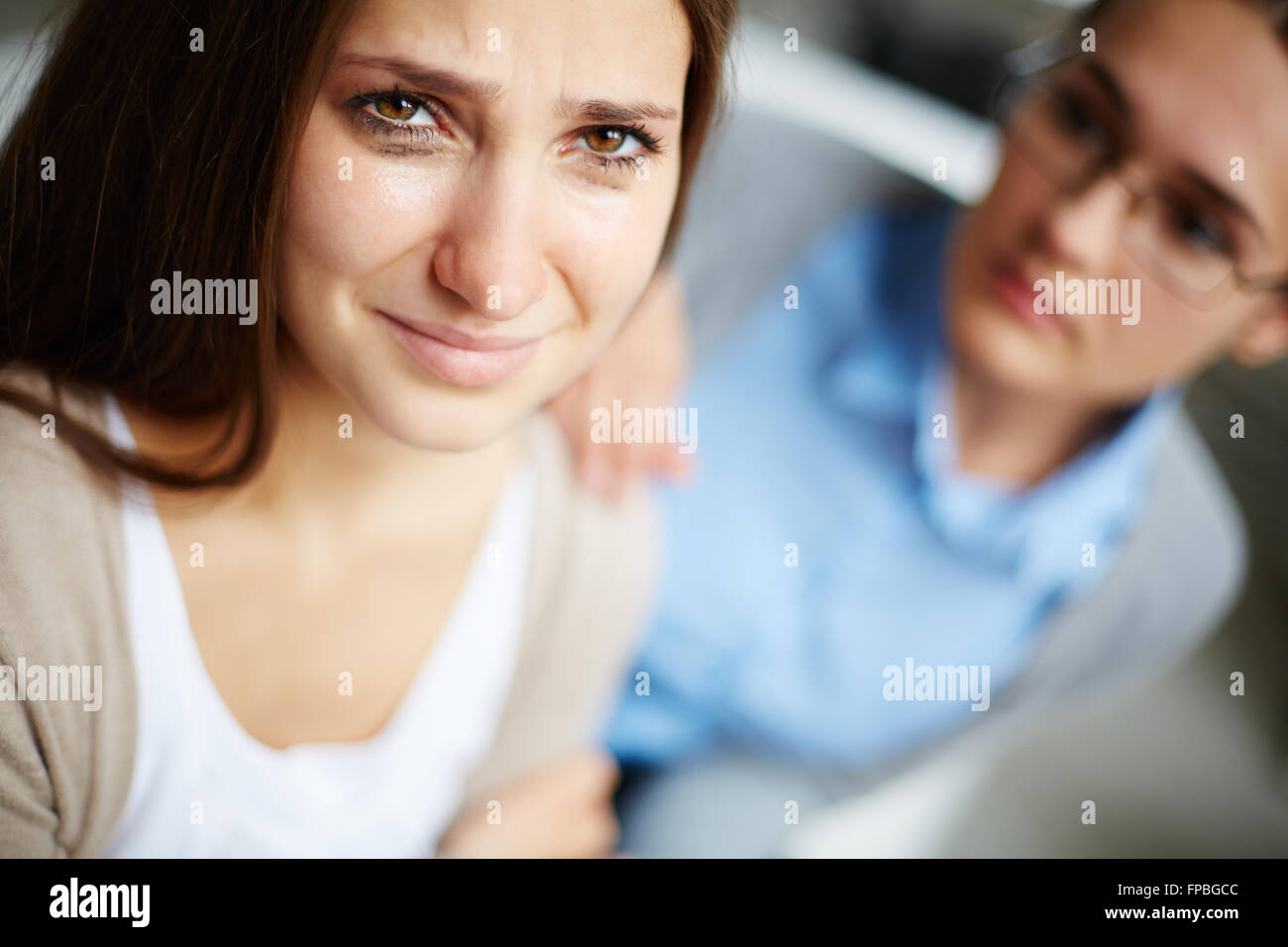 Woman crying and her friend supporting her in the background Stock Photo