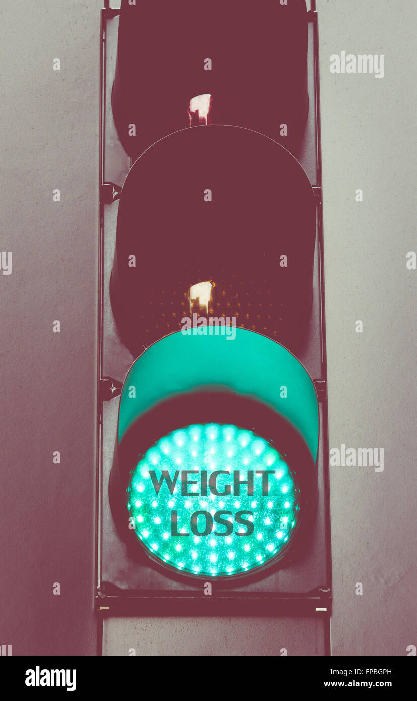 Close up on green traffic light with message WEIGHT LOSS. Motivational concept image with vintage filter applied Stock Photo