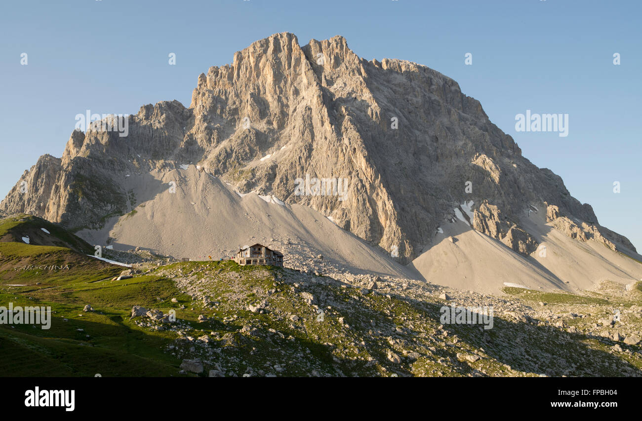 The Carschina mountain hut in front of the step rock face of the Mount Sulzfluh , canton of Grisons in Switzerland Stock Photo