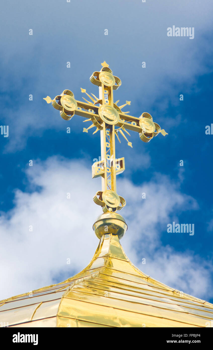Close-up of Golden crucifix and Cupola of Orthodox church and blue sky with clouds Stock Photo
