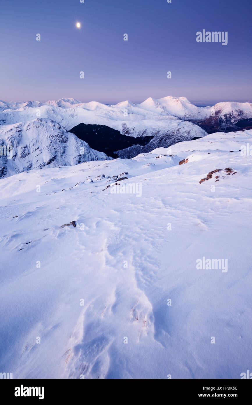 A moon over the wintry summits of the Arnisdale mountains at dawn, Glenelg, from Sgurr Mhic Bharraich during winter Stock Photo