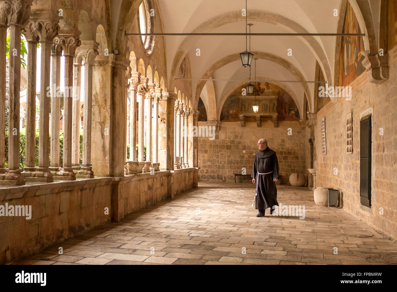 A monk inside the cloisters of the Franciscan Monastery in Dubrovnik, Croatia. Stock Photo
