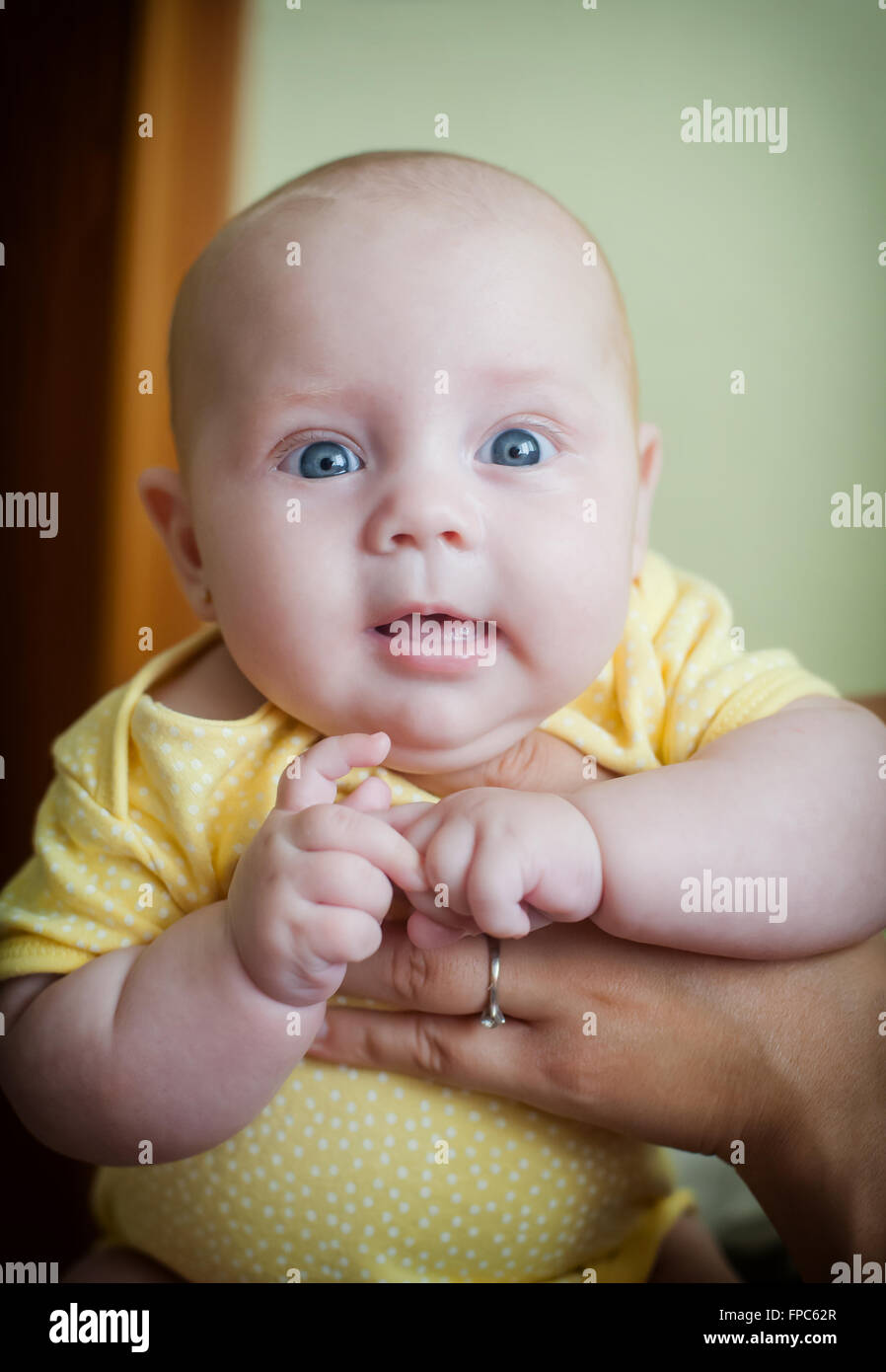 Sweet little cute girl in mom's arms Stock Photo