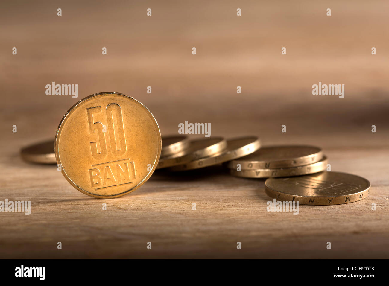 Stacks of Romanian fifty bani coins on wooden table, with selective focus Stock Photo