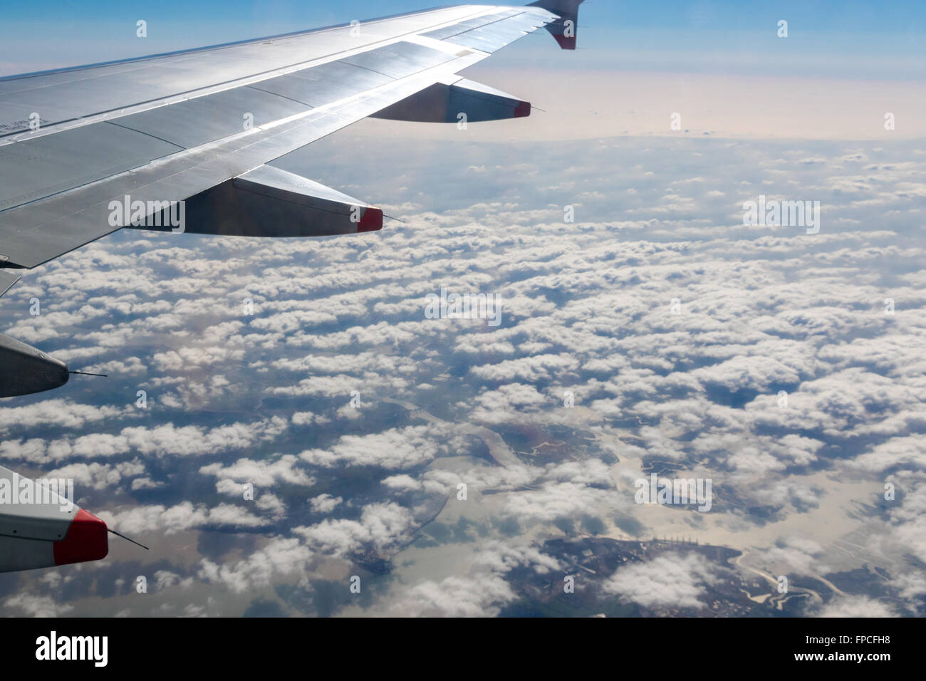Wing of an airplane flying above the clouds Stock Photo - Alamy