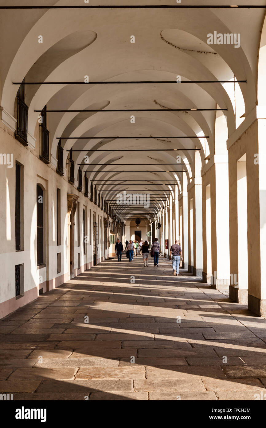 People walking through archways, outside the Savoy Armeria Reale. Stock Photo
