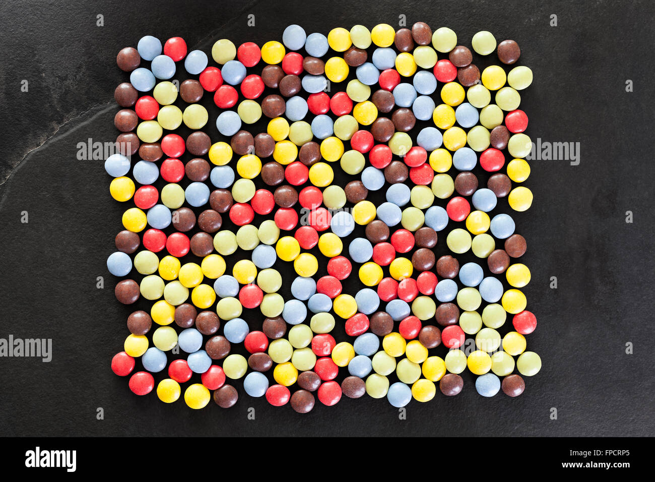 Colorful candy on a black stone background. Stock Photo