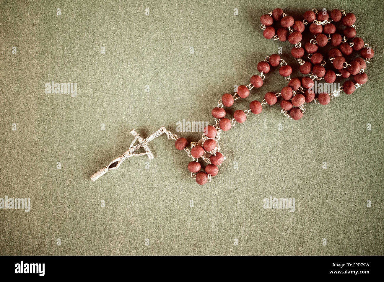 Catholic rosary on dark green background with copy-space for your text