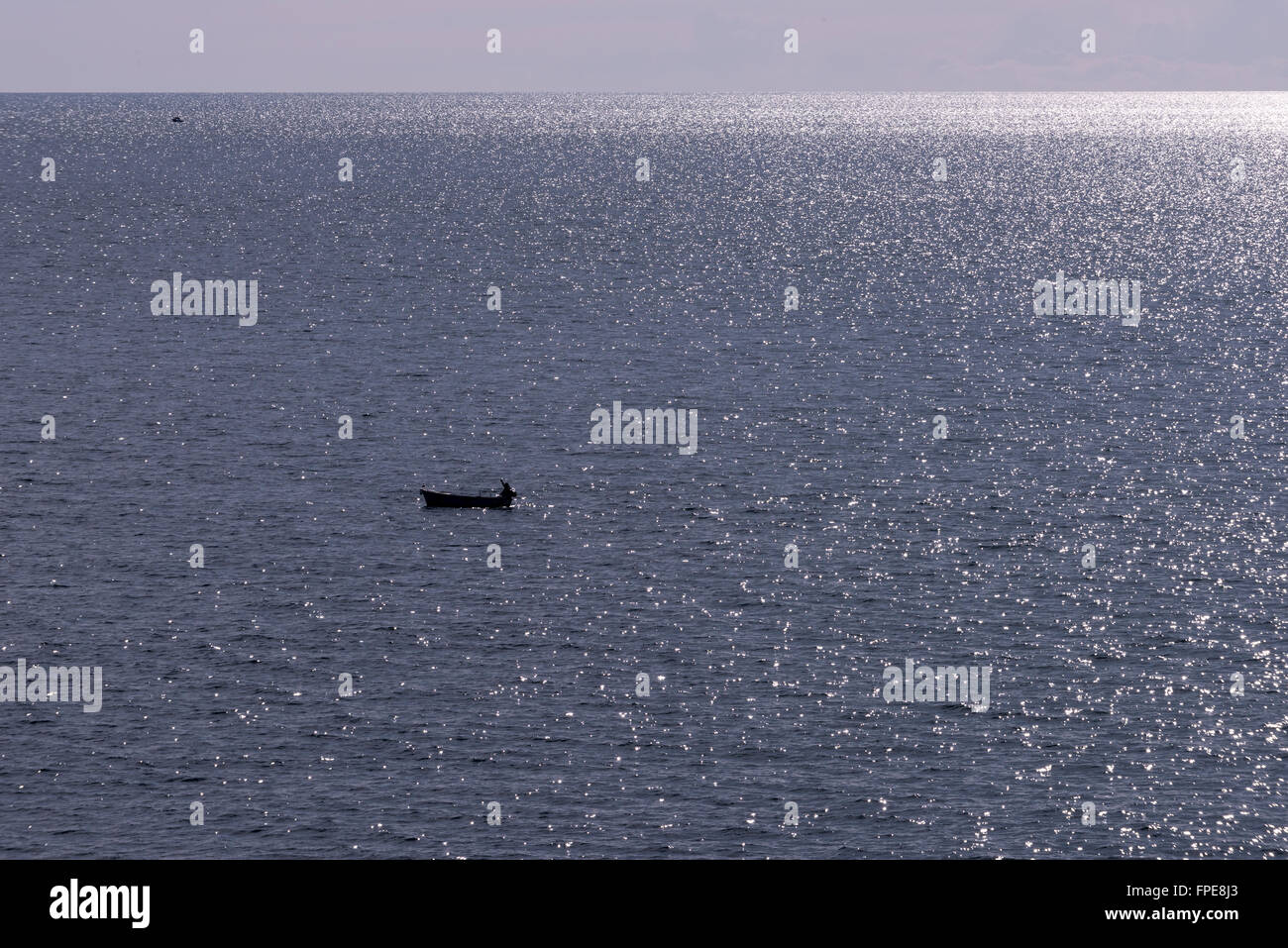A lone fisherman on a sparkling Adriatic Sea, near Dubrovnik, Croatia. Stock Photo