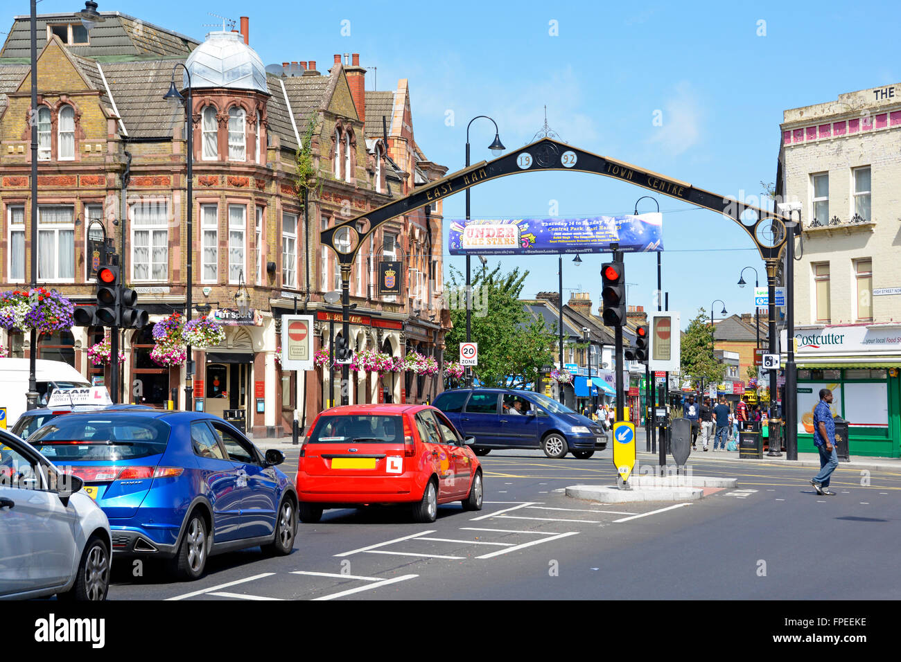 Multicultural East Ham London Borough of Newham street scene with cars at traffic lights on junction of High Street North and Barking Road England UK Stock Photo