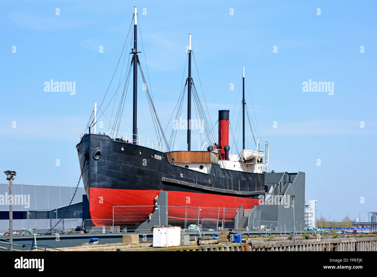 SS Robin steam coaster mounted on floating pontoon undergoing restoration work to become a floating museum seen Royal Docks Newham London England UK Stock Photo