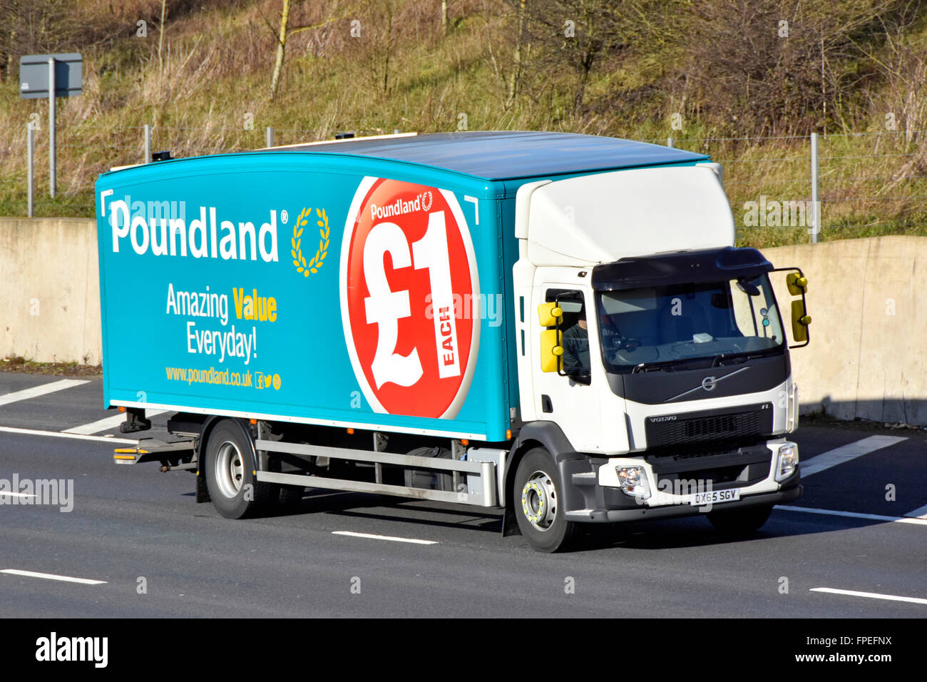 Supply chain transport logistics via Poundland store delivery lorry with aerodynamic shape and advertising on side driving along English UK motorway Stock Photo