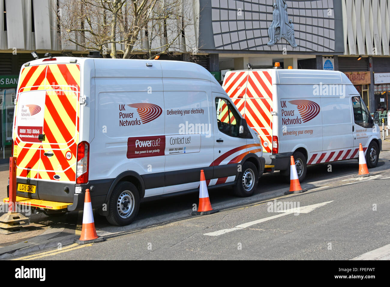 Two UK Power Networks commercial vehicle vans parked up during street works to underground electricity supplies  East Croydon South London England UK Stock Photo