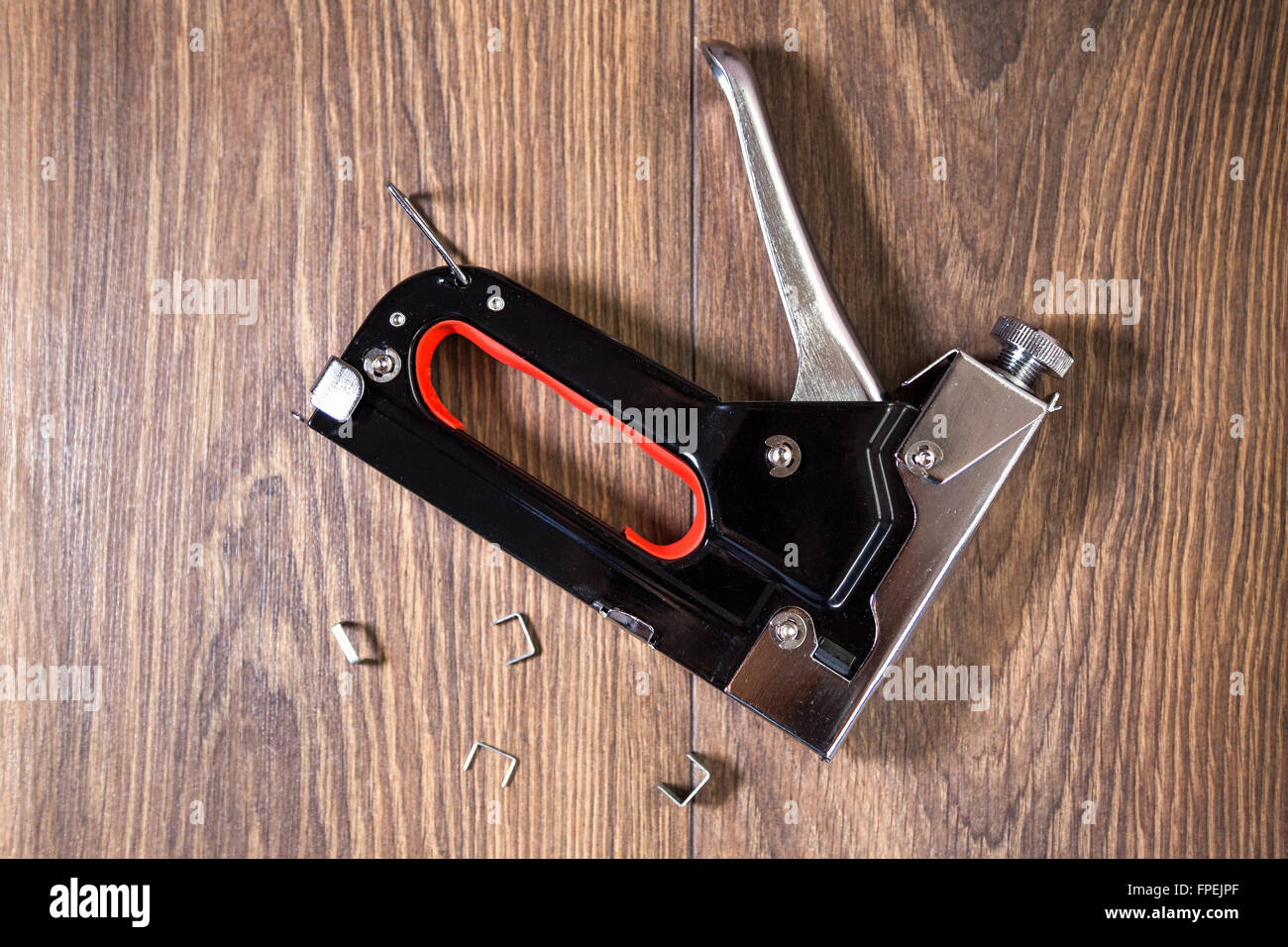 Carpentry stapler ,Construction machinery held stapler on wooden background Stock Photo