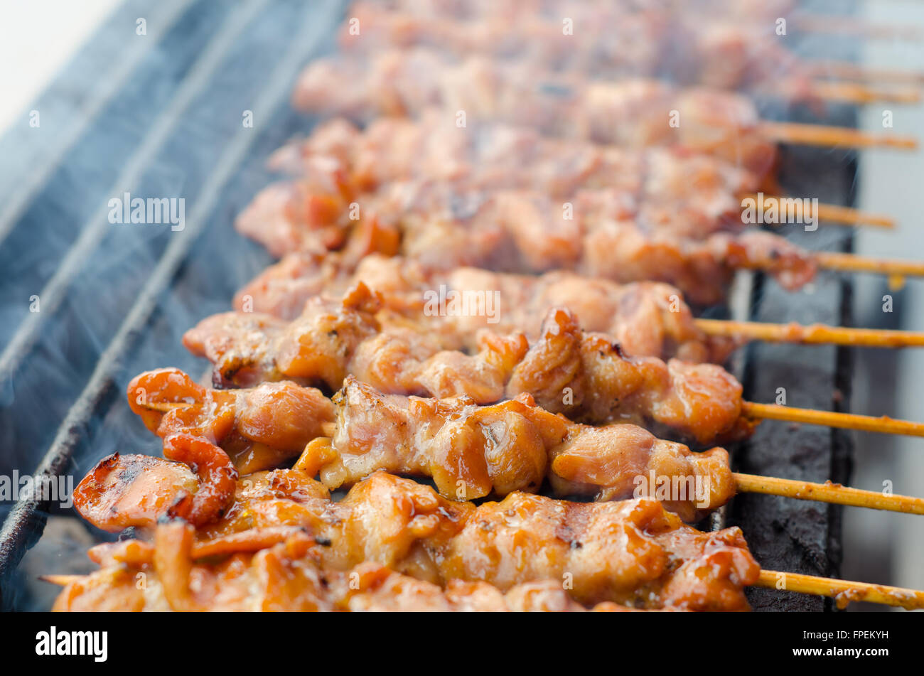 Skewer chicken pieces roasting on the grill and smoke Stock Photo