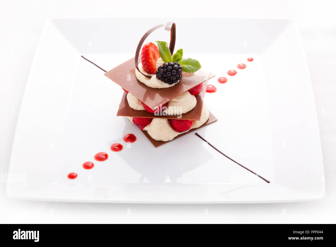 Dessert of thin layers chocolate, cream, berries Stock Photo