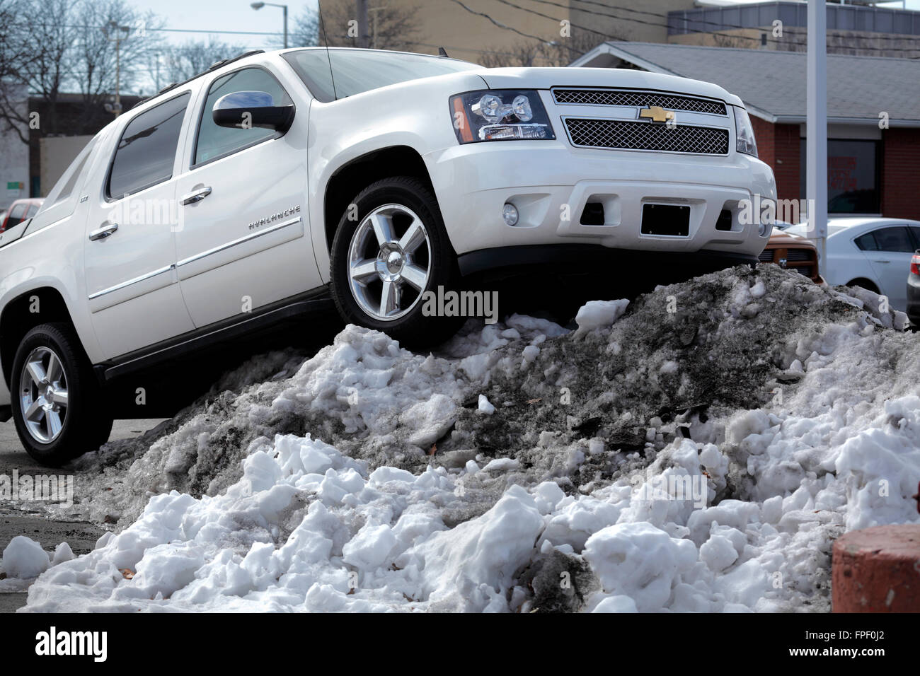 A Chevrolet Avalanche parked on a dealer lot upon a snow pile. Stock Photo