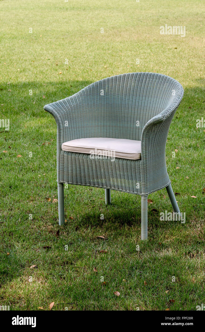 Grey water resistant rattan chair with cushion in the garden Stock Photo