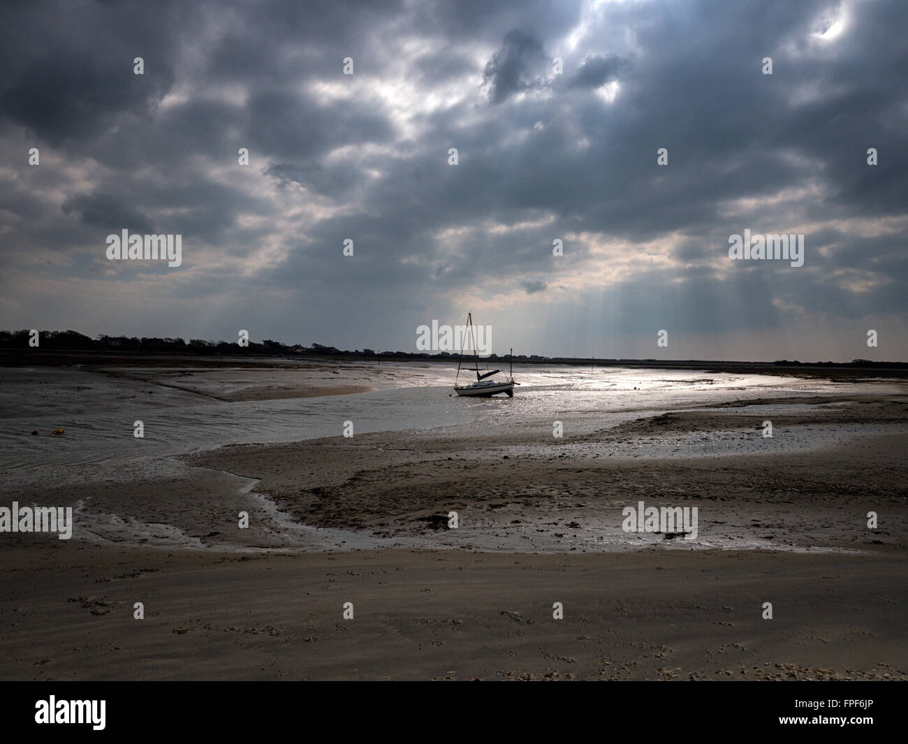 Beached yacht at low tide in a sandy creek by East Head, West Wittering