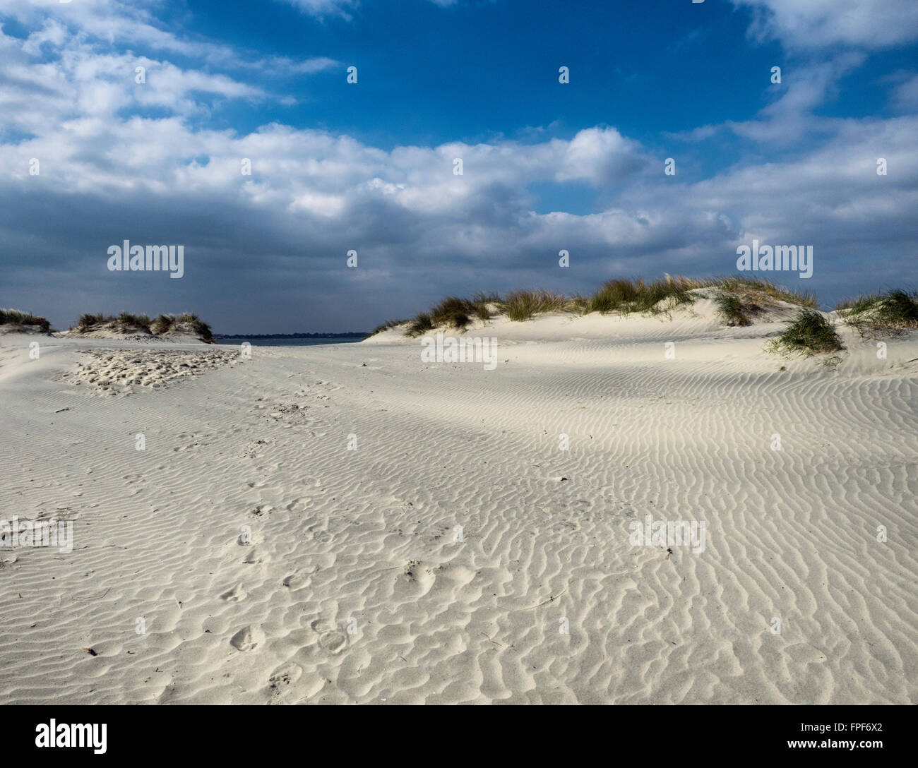 Footsteps in the sand by a dune at East Head, West Wittering, West Sussex Stock Photo
