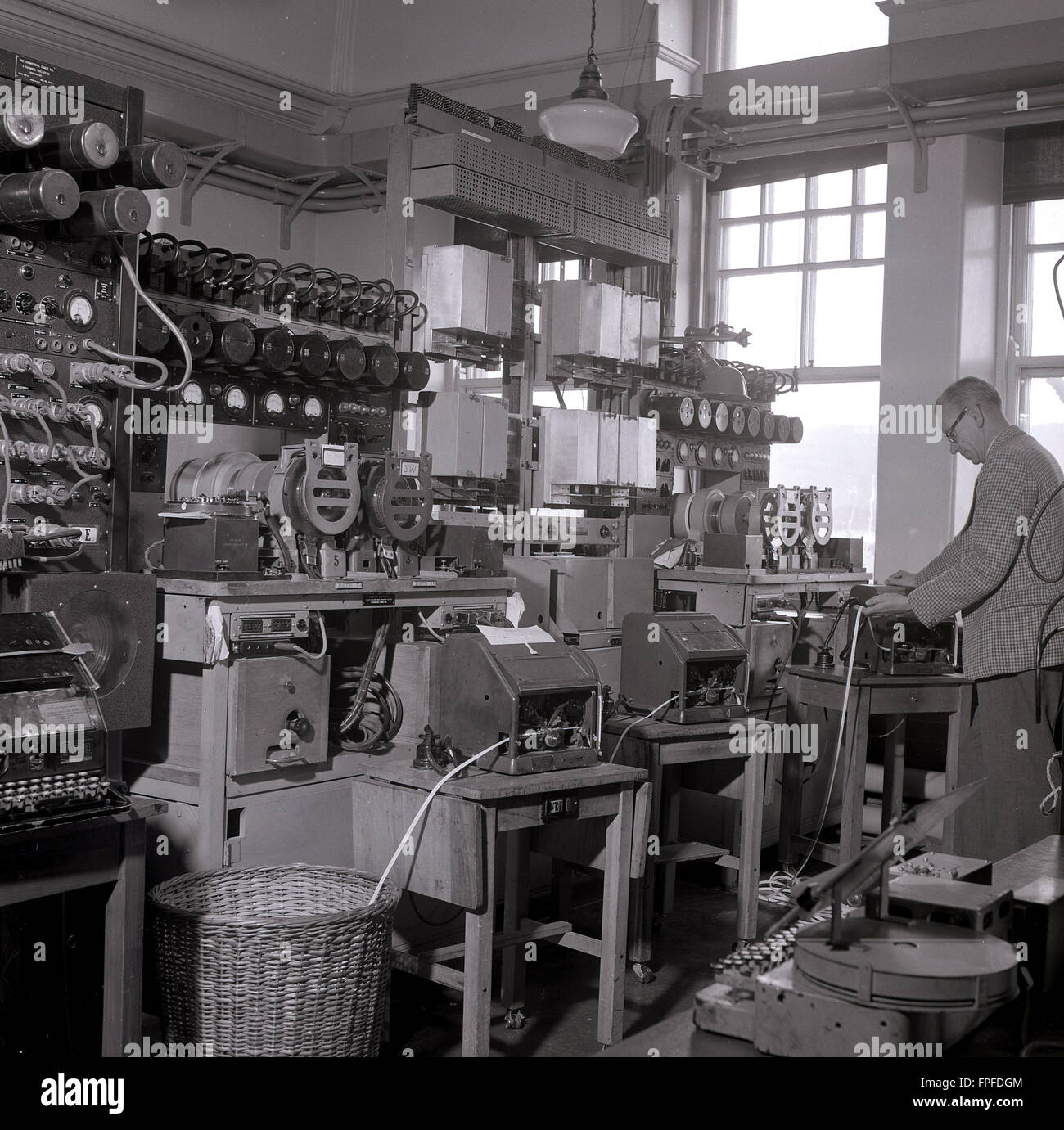 1950s, historical, a male engineer working on the telegraph equipment inside a circuit room at the transatlantic cable station in Waterville, Co. Kerry, Ireland, once home to the one of the largest cable stations in the world. The first successful transatlantic telegraph message was transmitted through Waterville in 1884, after the Commerical Cable Co had laid two cables across the Atlantic ocean connecting Canada, Britain and France, via Waterville, a total of 2,399 miles of cable. Stock Photo
