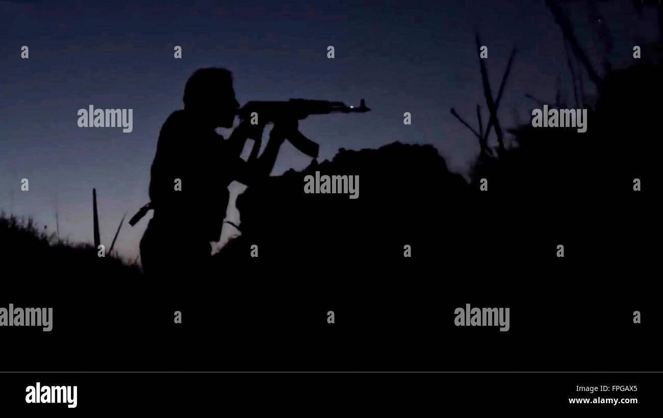 An ISIS propaganda video showing Islamic State militants silhouetted during a twilight battle along the border of Iraq and Syria in an area described as Wilayah al-Khayr January 13, 2016 near Deir ez-Zor, Syria. Stock Photo