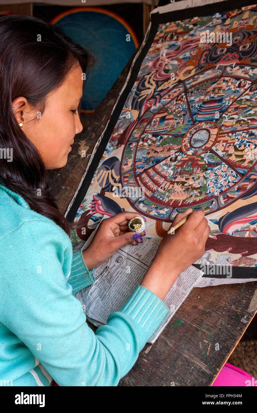 Nepal, Patan.  Young Woman Painting a Thangka, a Tibetan Buddhist Painting. Stock Photo