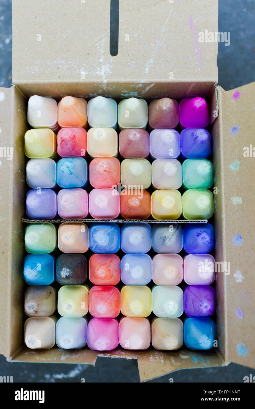 Sidewalk chalk box freshly opened on summer day at park with vibrant colors Stock Photo