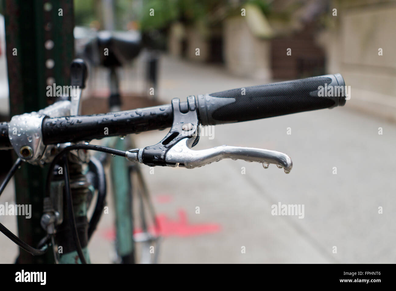 Urban bicycle attached to pole after rain Stock Photo