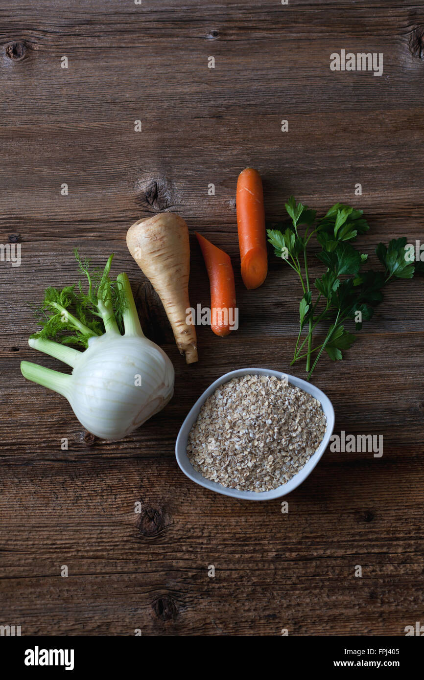 Fennel, parsnip, carrot, parsley and oats on the rustic wooden table Stock Photo