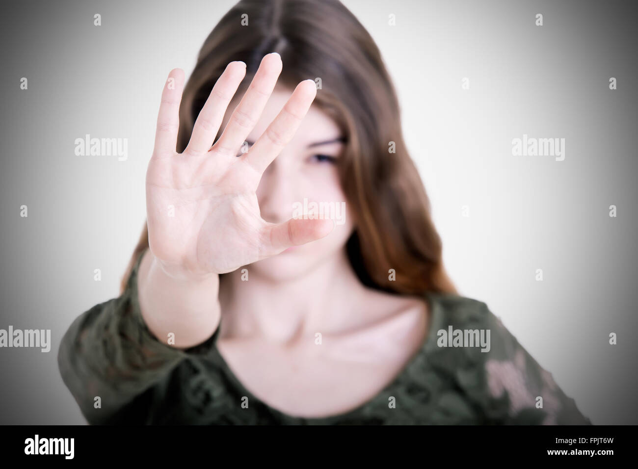Closeup of a woman protecting herself from an aggressor, with a dark vignette Stock Photo