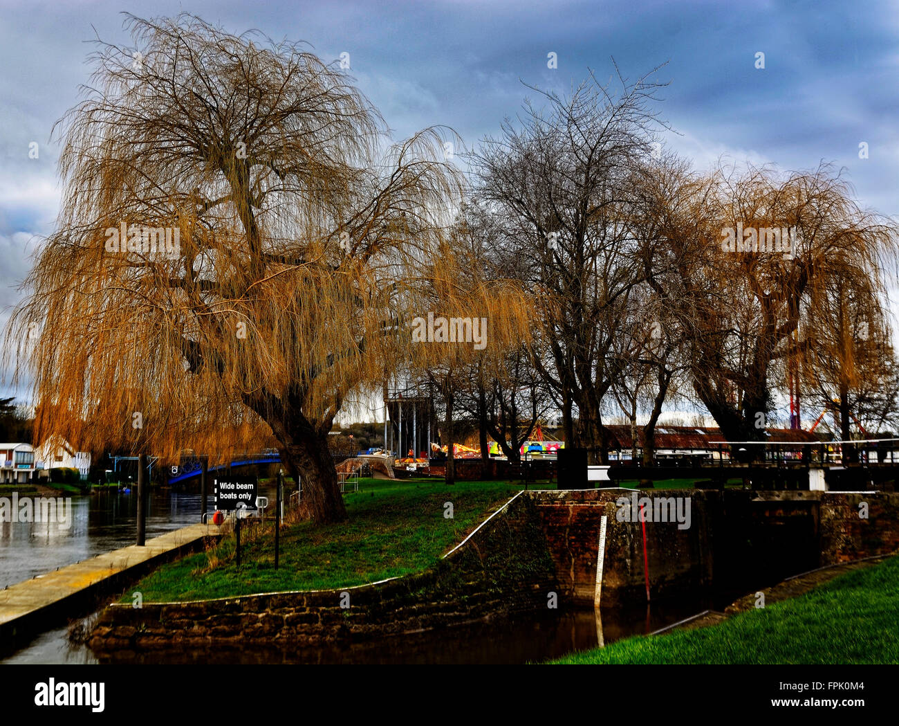 Willow trees over the River Severn signal the canal basins at the town of Stourport over a placid eddying water Stock Photo
