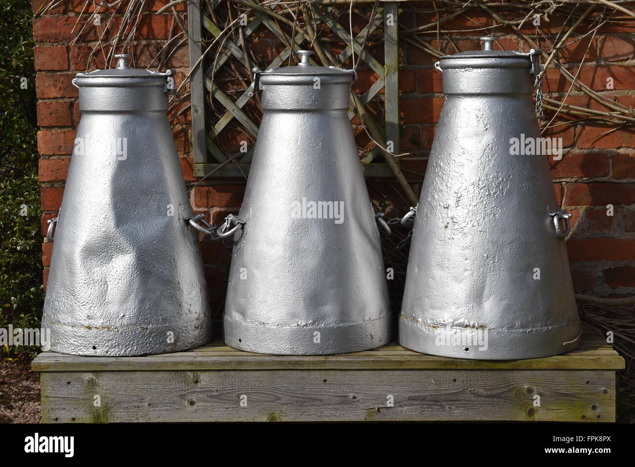 Milk churns in Lower Heswall village, Wirral, Merseyside. Stock Photo