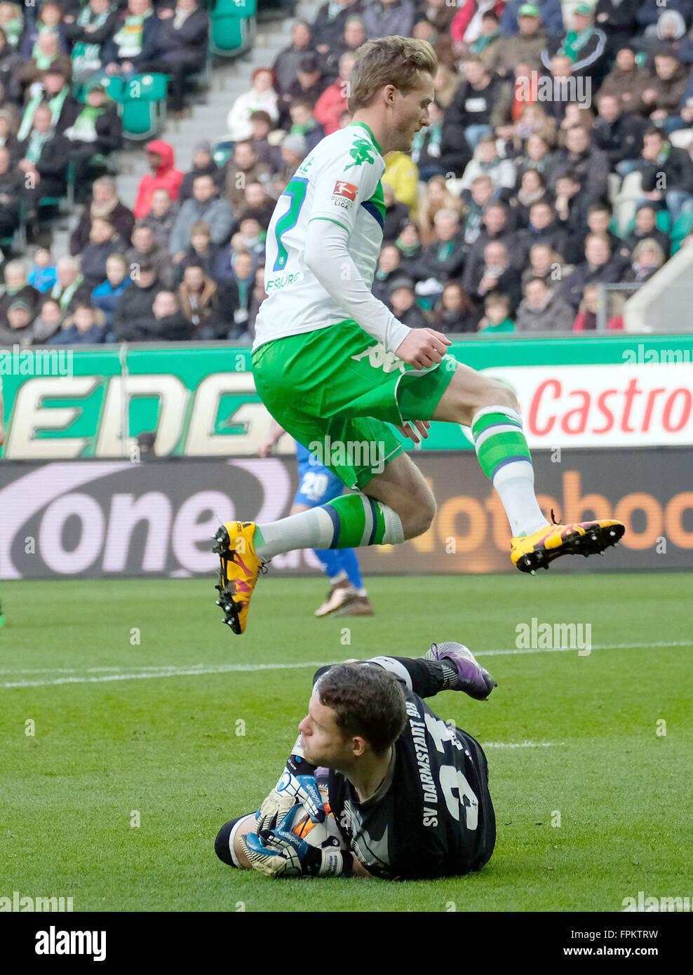 Wolfsburg's Andre Schuerrle (top) and Darmstadt's goalkeeper Christian Mathenia in action during the German Bundesliga soccer match between VfL Wolfsburg and SV Darmstadt 98 at the Volkswagen arena in Wolfsburg, Germany, 19 March 2016. PHOTO: PETER STEFFEN/dpa    (EMBARGO CONDITIONS - ATTENTION: Due to the accreditation guidlines, the DFL only permits the publication and utilisation of up to 15 pictures per match on the internet and in online media during the match.) Stock Photo