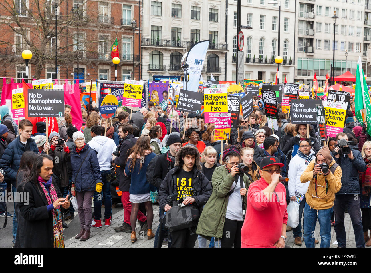 London, 19th March 2016.  Protesters begin to gather at the 'Stand up to Racism' demonstration as it begins in Portland Place. The rally against racism, islamophobia and current refugee policies was attended by thousands of demonstrators from trade unions, activist and cultural organisations, religious representatives and members of the public Credit:  Imageplotter News and Sports/Alamy Live News Stock Photo