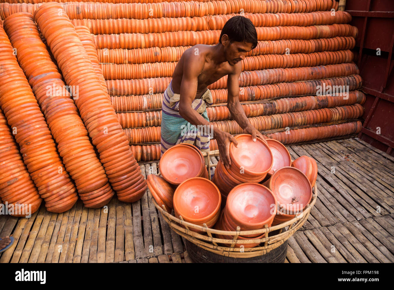 Dhaka, Bangladesh. 19th Mar, 2016. A worker is delivering clay plate to