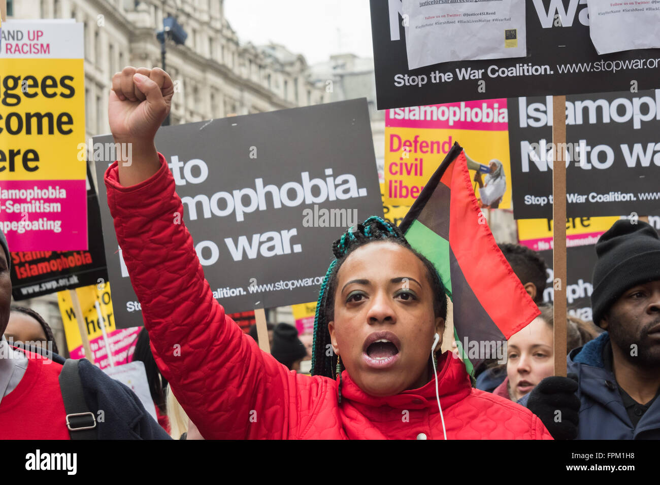 London, UK. Saturday 19th March 2016. A woman in the 'Black Lives Matter' bloc gives a raised fist salute n the march through London from the BBC in a national demonstration organised by Stand Up to Racism against racism, Islamophobia, anti-Semitism and fascism and to say clearly that refugees are welcome here.  Peter Marshall/Alamy Live News Stock Photo