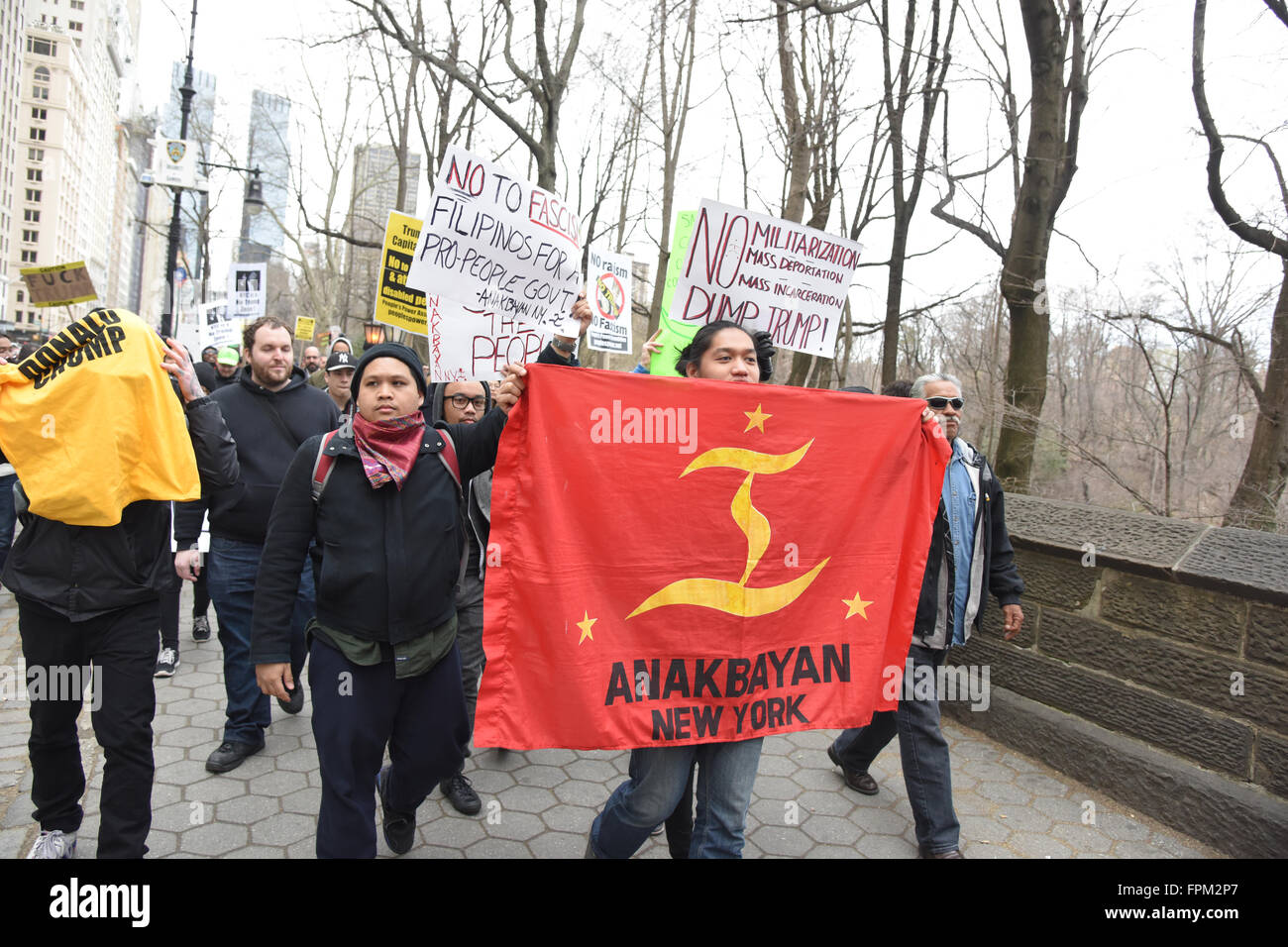 New York, USA, 19 March 2016: Anakbayan flag carried along 59th Street during NYC rally against Republican front runner Donald Trump Credit:  Andrew Katz/Alamy Live News Stock Photo