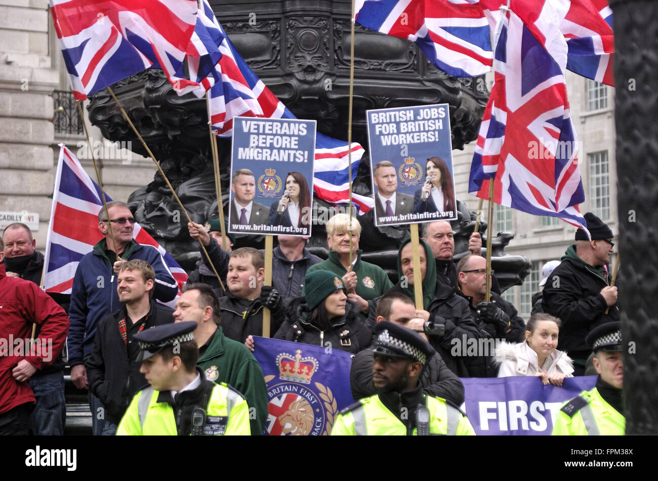 London, UK. Saturday 19th March 2016. Anti-refugee Britain First members are protected from antifascist protestors by police. Stock Photo