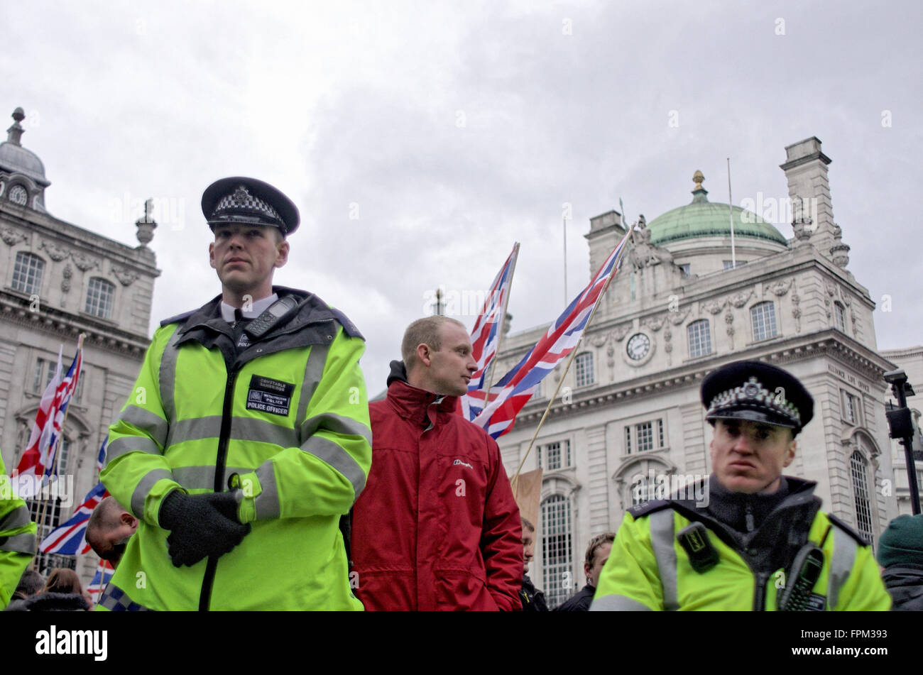 London, UK. Saturday 19th March 2016. Police protect a Britain First member from antifascist protesters. Stock Photo