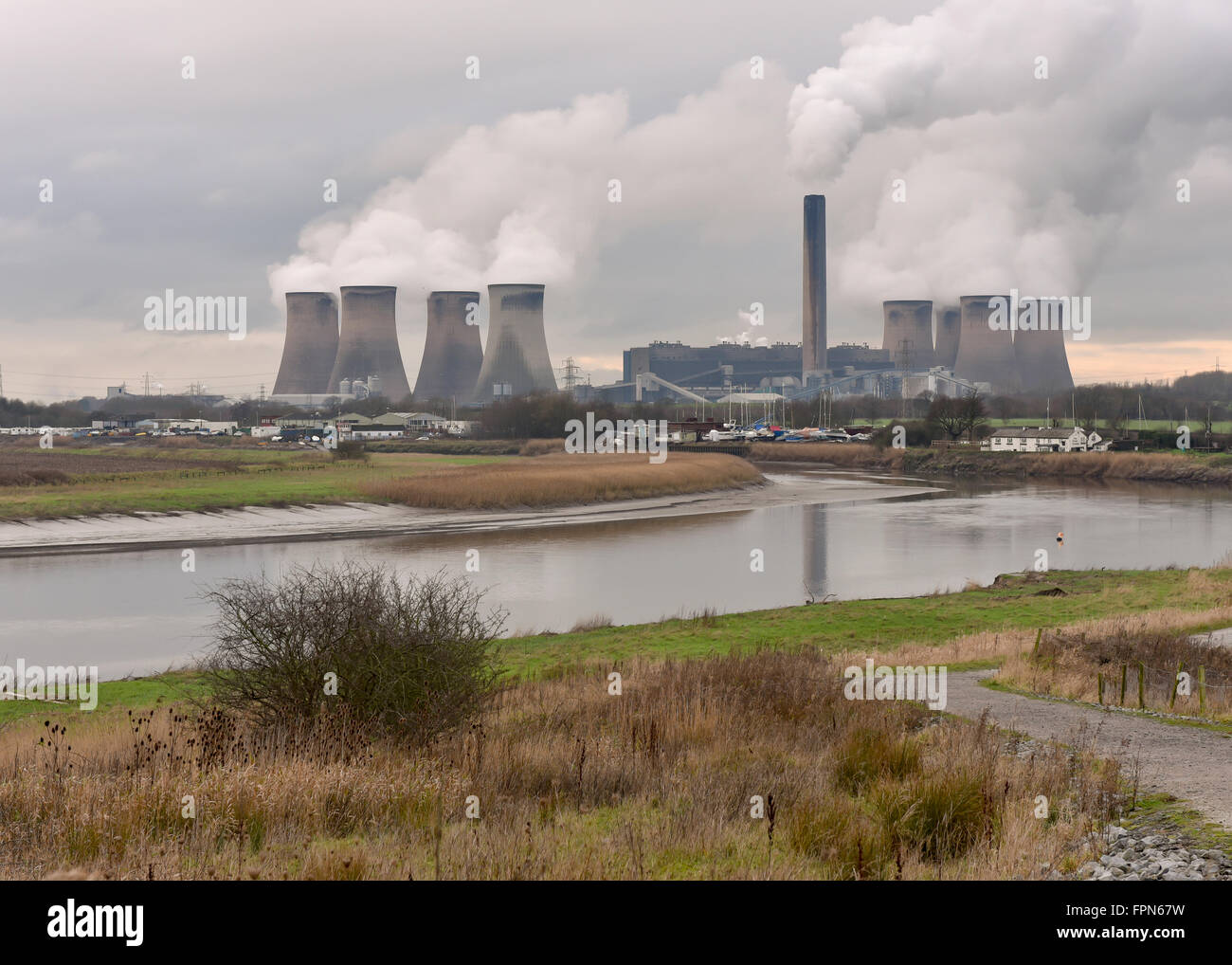 Widnes, Cheshire, Fiddler's Ferry coal powered power station from the Mersey River in winter with clouds of smoke from the chimn Stock Photo