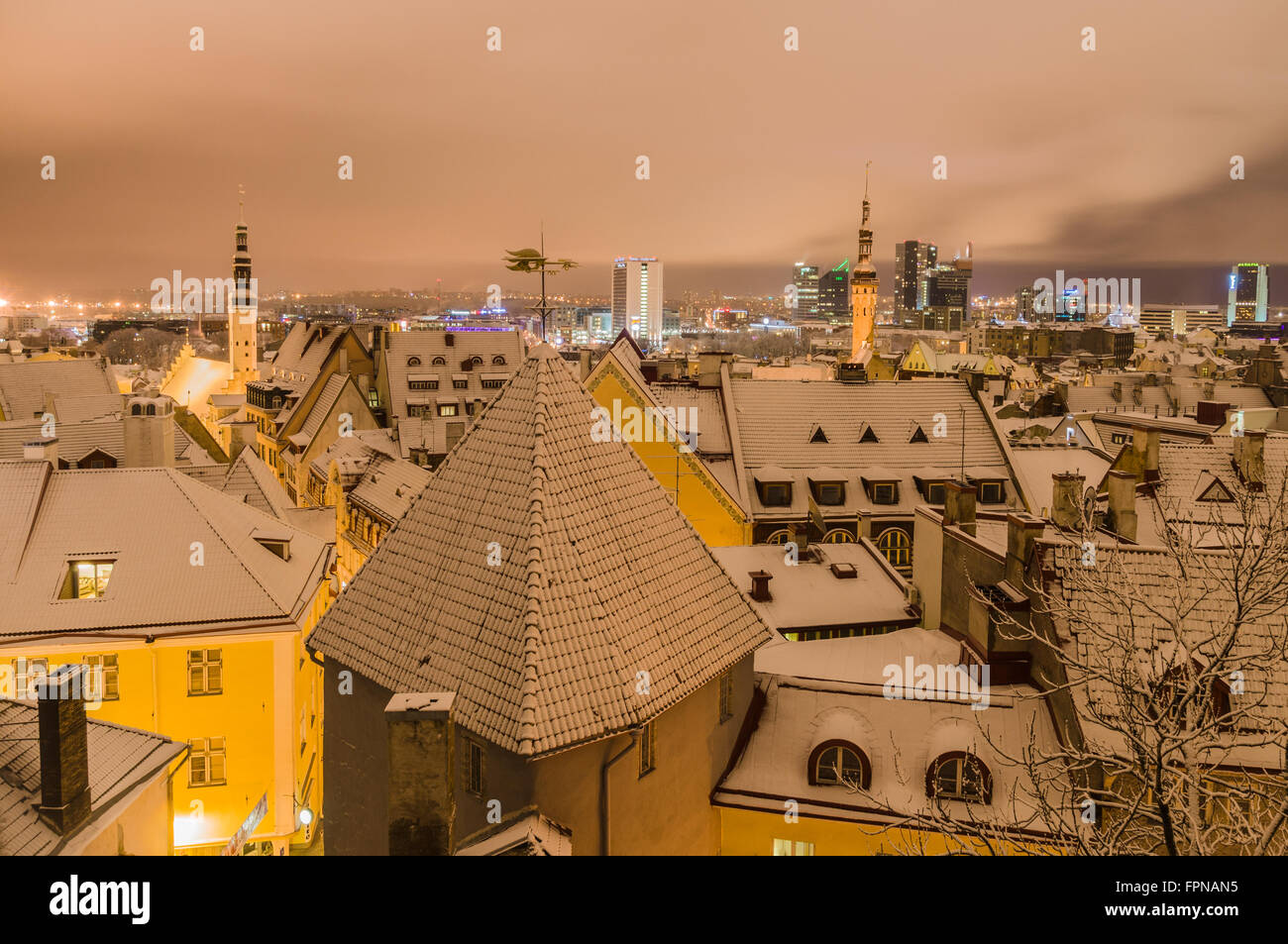 Winter time view on snowbound old town and modern city at night, Tallinn, Estonia Stock Photo
