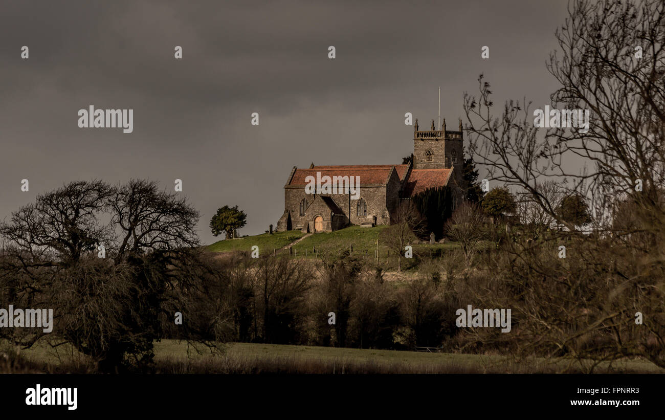Saint Arildas Church under heavy grey skies in Oldbury On Severn, South Gloucestershire Stock Photo