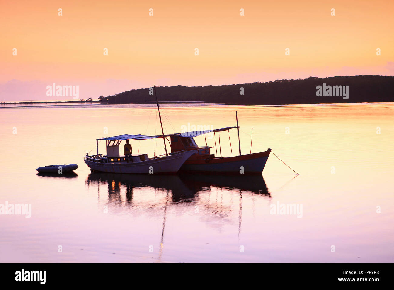 Fishing boat at sunset Stock Photo - Alamy