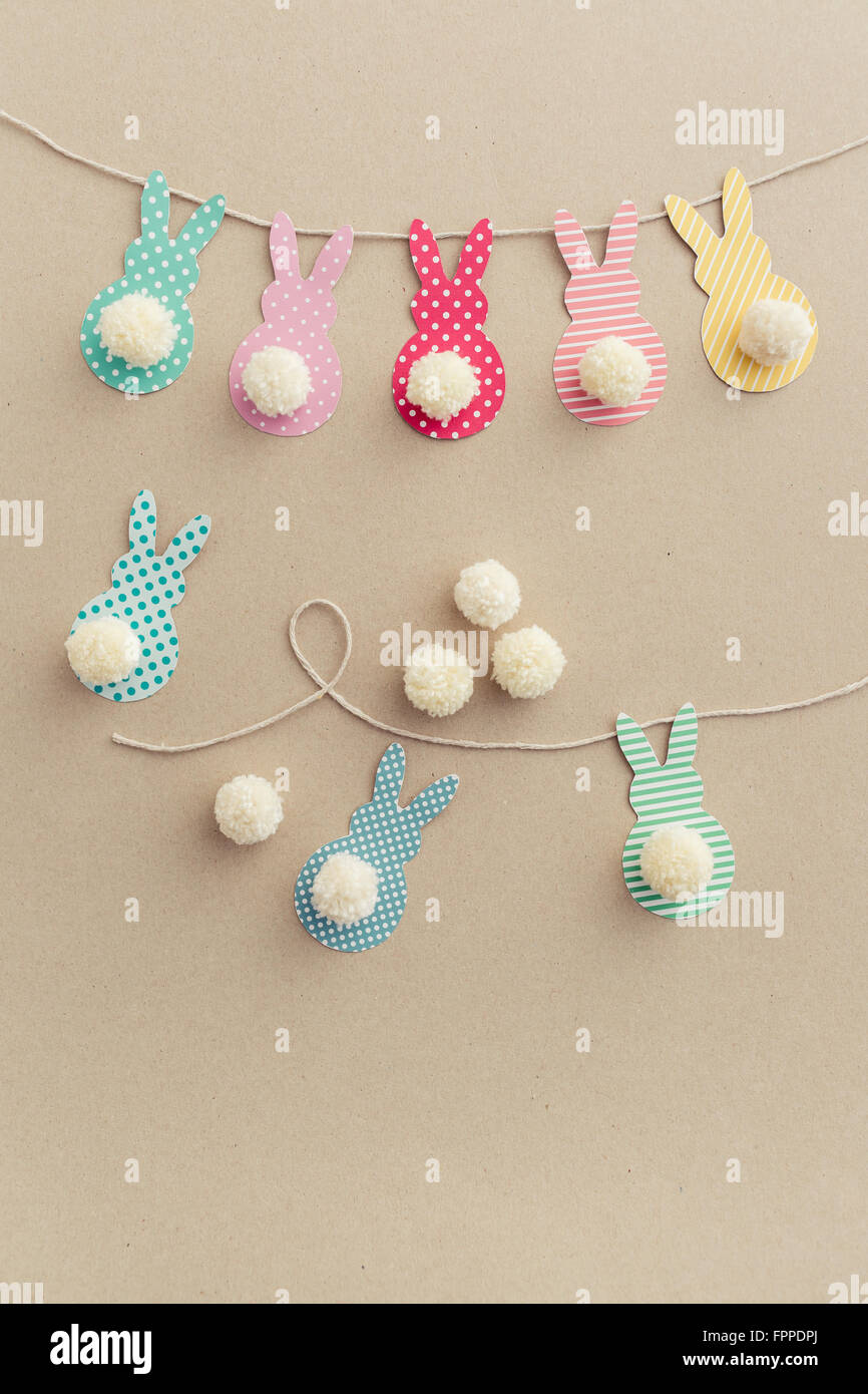Easter Bunny Banner. Cute bunny shapes with yarn pom pom tails. Stock Photo
