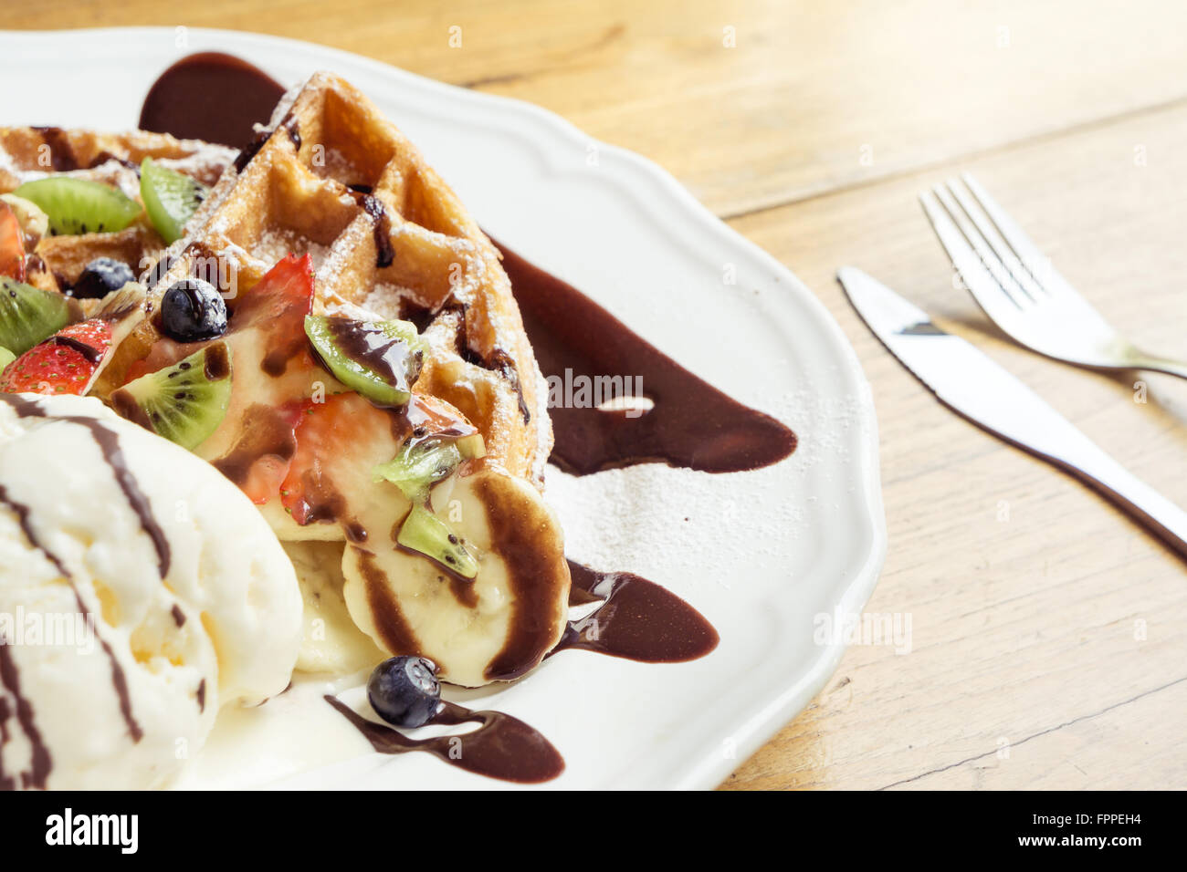 Ice cream waffle with chocolate fudge strawberry berry and kiwi top view Stock Photo